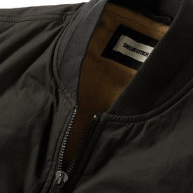 material shot of the collar and zipper on The Ignition Vest in Coal Dry Wax