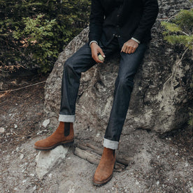 fit model sitting on a rock in The Slim Jean in Cone Mills Cordura Denim