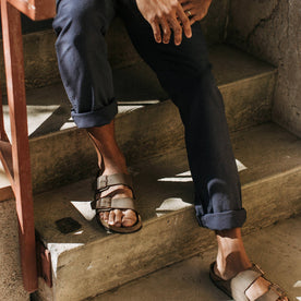 our fit model wearing The Gibson Trouser in Navy—sitting on stairs