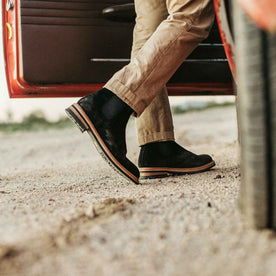 our fit model wearing The Ranch Boot in Coal Weatherproof Suede—walking toward truck