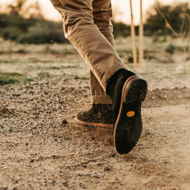 our fit model wearing The Ranch Boot in Coal Weatherproof Suede—kicking up dirt