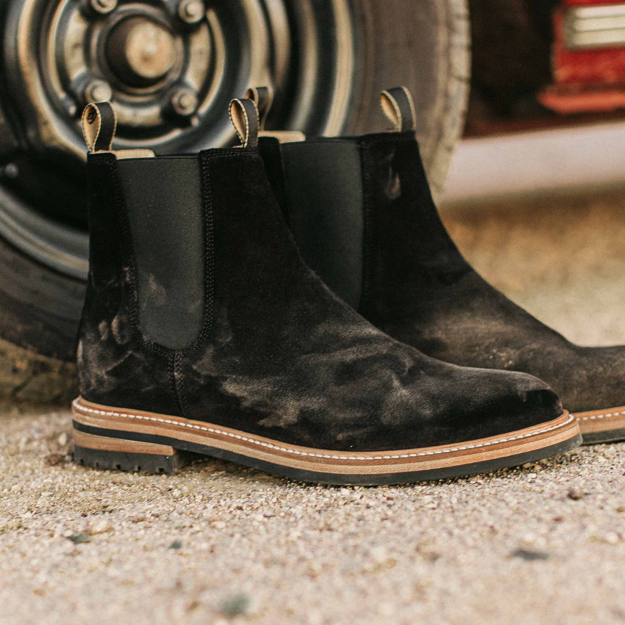 material shot of The Ranch Boot in Coal Weatherproof Suede—next to car, Footwear by Taylor Stitch