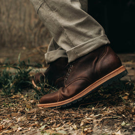 our fit model wearing The Moto Boot in Chocolate Pebble Grain—close up of left boot
