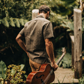 our fit model wearing The Caravan Shirt in Walnut Double Cloth—walking with guitar