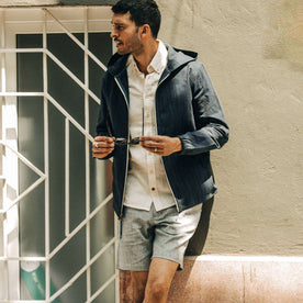 fit model wearing The Riptide Jacket in Indigo Slub, playing with sunglasses