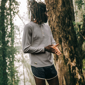 fit model wearing The Shoreline Henley in High Rise, looking right on trail