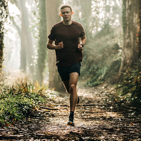 fit model wearing The Traverse Short in Navy, running on trail