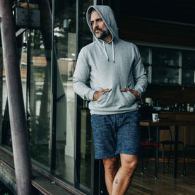 our fit model wearing The Après Short in Indigo Slub—wearing a hoodie early in the morning