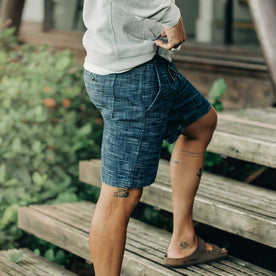 our fit model wearing The Après Short in Indigo Slub—wearing a hoodie early in the morning, cropped shot walking