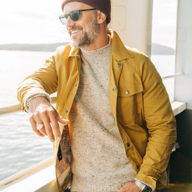 fit model wearing The Lombardi Jacket in Mustard Dry Wax, smiling on ferry