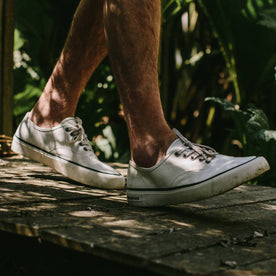 fit model wearing The Vista Sneaker in Natural Boss Duck, walking on pathway