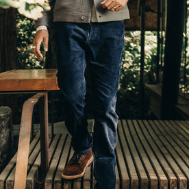 our fit model wearing The Camp Pant in Indigo Corduroy—standing on wooden deck