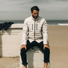 our fit model wearing The Taylor Stitch x Mission Workshop Farallon Jacket in fog—sitting near beach