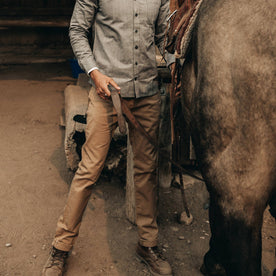 fit model wearing The Slim All Day Pant in Rustic Oak Organic Selvage, next to horse